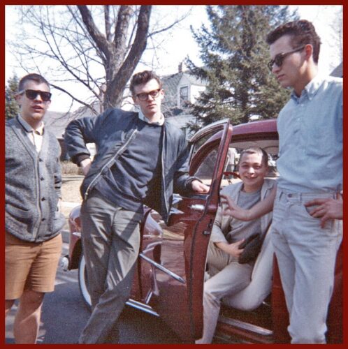 Four tenage boys around a car